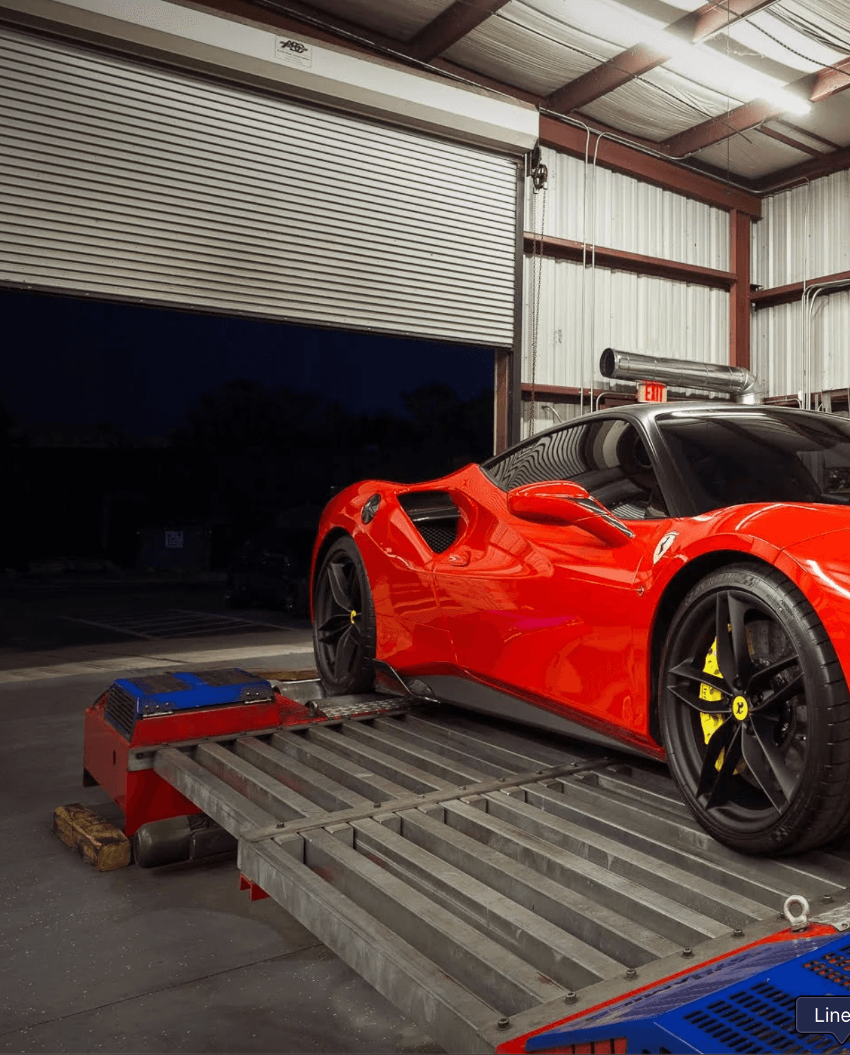 Red Ferrari strapped to a dynamometer inside the Formula Dynamics workshop